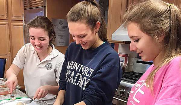 Mount Mercy Academy students Bridgit Hayes (left to right), Morgan Bentkowski and Madelyn Bentkowski prepare dinner at the Ronald McDonald House as part of the Cooks for Kids program. 