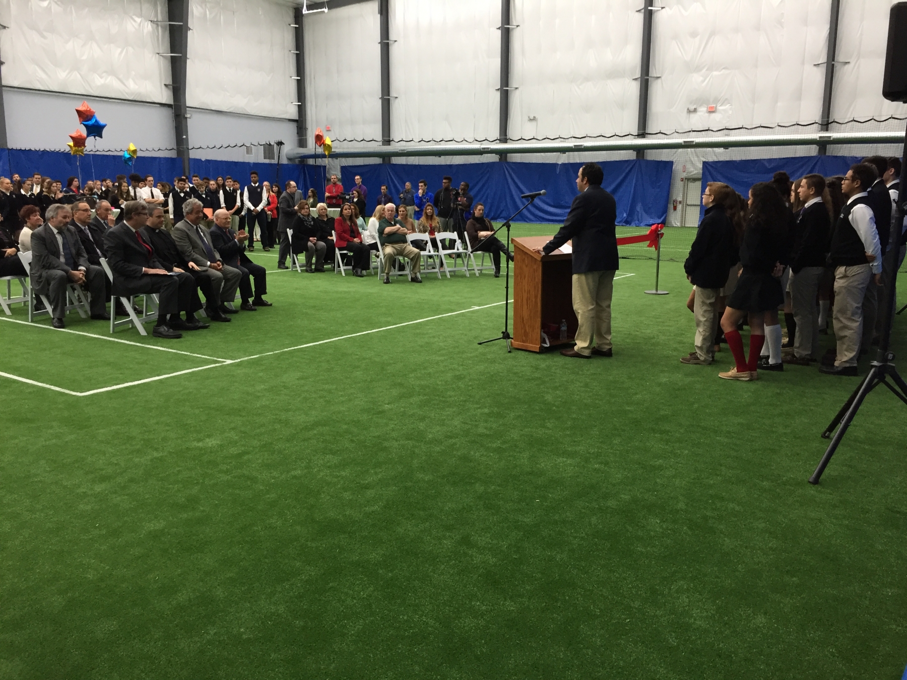 Students from Niagara Catholic Junior and Senior High School attend a ribbon cutting ceremony for The Niagara Community Center behind their school.