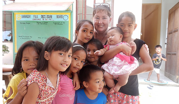 Sarah Noonan (back center) with some of the barrio children during the Multiplication of Loaves feeding program of the Sisters of the Poor. (Courtesy of Sarah Noonan)