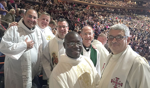 Buffalo priests Father Joseph Gullo (from left), Father Piotr Zaczynski, Father Jeffrey Nowak, Father Patrick Zengierski and Father Joseph Porpiglia, along with a new friend from Africa, join a crowd of 20,000 for Mass with Pope Francis at Madison Square Garden on Sept. 25. (Courtesy of Father Jeffrey Nowak)