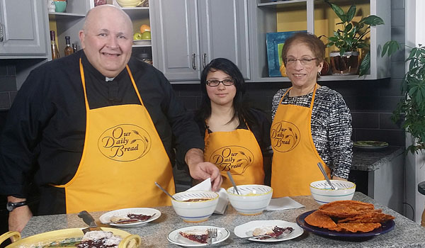 Father Paul D. Seil learns more about the TRY Program as he cooks with Estefania, a resident, and Sister Janet DiPasquale, the executive director of the program.