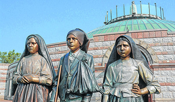 Statues of the three children who witnessed the apparitions of the Blessed Virgin at Fatima stand outside the main entrance to the Basilica of the National Shrine of Our Lady of Fatima, Lewiston. The statues were unveiled May 13, the same day two of the children were canonized. (Patrick McPartland/Managing Editor)