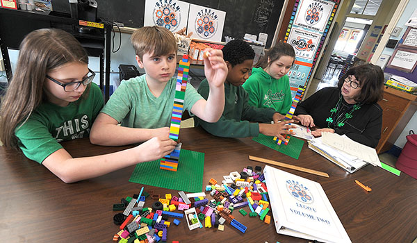 Our Lady of Victory School STREAM coordinator Marian Abram works with sixth-graders Sophia Turchiarelli (from left), Alex Viterna, Eugene Davis III and Lizy Sibley, as the students construct earthquake-proof tower models during the `Lego U` portion of the STREAM program. (Dan Cappellazzo/Staff Photographer)