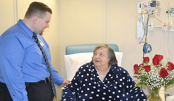 Rev. Daniel Brockhan, chaplain at Mercy Hospital of Buffalo, visits with patients like Christine Chandler spreading a message of hope and healing. (Catholic Health)
