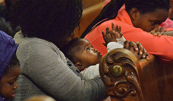 A young child looks to the murals on the ceiling of Our Lady of Hope. (Dan Cappellazzo/Staff Photographer)