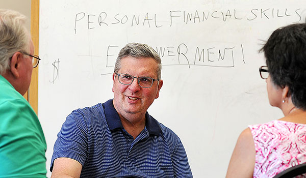 In an effort to help alleviate poverty in Eastern Niagara County, St. John the Baptist's Community Outreach director Michael Boron helps a couple with their financial skills. Classes, which will be offered through the Outreach office, aim to help low-income residents better manage their money and plan for the future. (Dan Cappellazzo/Staff Photographer)