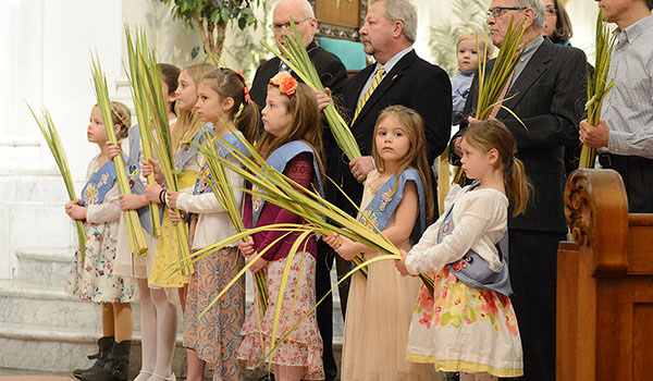 Members of the Little Flowers Girl Club stand with palms before the start of Palm Sunday Mass at St. Joseph Cathedral. (Patrick McPartland/Managing Editor)