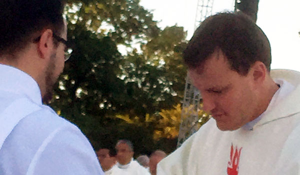 Deacon Samuel Giangreco (left) gives Communion to Father Ryszard Biernat during the canonization Mass celebrated by Pope Francis in Washington, D.C.