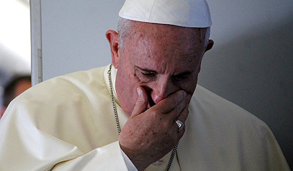 Pope Francis prays with journalists on the papal flight in August 2014. (Alan Holdren/CNA)