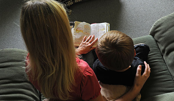 Angel, a pregnant young mother who is a survivor of domestic violence, reads the Bible with her son. (Dan Cappellazzo/Staff Photographer)