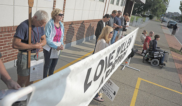 Respect Life sidewalk advocates pray as they stand outside an abortion clinic on Main Street in Buffalo. (Dan Cappellazzo/Staff Photographer)