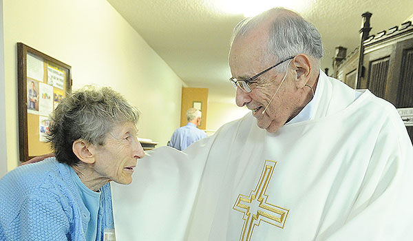 Retired priest Msgr. Angelo Caligiuri, 84, speaks with volunteer Cynthia DiMartina after Mass at St. Joseph University Church. A special collection will be held for the retired priests fund on Aug. 6. (Dan Cappellazzo/Staff Photographer)