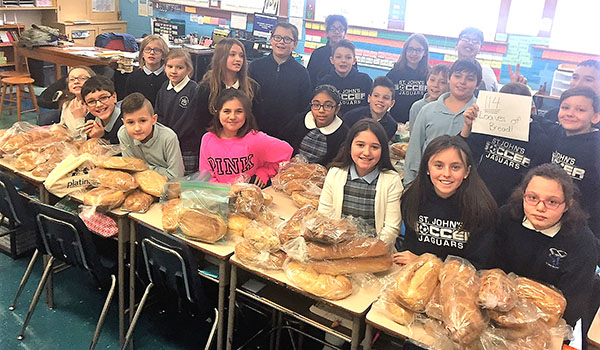 St. John's fifth-grade with some of the 114 loaves of bread they baked. (Courtesy of St. John the Baptist School)