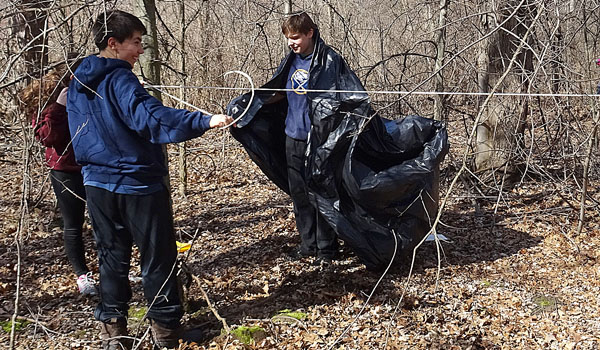 Michael Trapasso (left) and Michael Dobrasz (right) build a survival shelter in the woods behind Stella Niagawwra Education Park as part of its Outdoor Education Program.