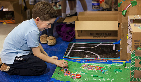 Owen Beebe tries out one of the Academy Arcade games at the STREAM Exhibition Night. (Courtesy of St. John the Baptist School)