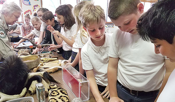 Fifth-graders Patrick Beck (left to right), Luke Colpoys and Arad Sadaghiani study a spider. Students were provided an opportunity to see and touch items brought to Christ the King School by the Buffalo Zoo Mobile. The Zoo Mobile visited Christ the King School, providing a hands-on experience.