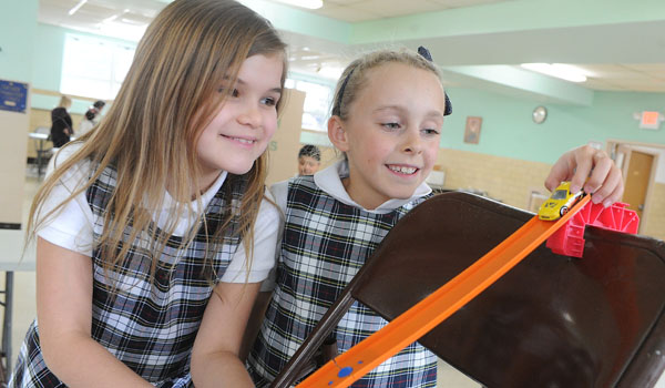 Immaculate Conception School third-graders Julia Wik and Sierra Reger participate in a STREAM Academy Hot Wheels track building exercise in the school cafeteria. The program at the East Aurora school features many activities including Kitchen Chemistry, Invention Convention, Rockin' Roller Coaster, Science Scrimmage and many more. (Dan Cappellazzo/Staff Photographer)