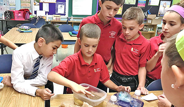 Trey Garvey (from left), Michael Taft, Luke Deakin and Josh Morgante use inquiry and exploration during science class at St. Gregory the Great School. (Courtesy of St. Gregory the Great School)
