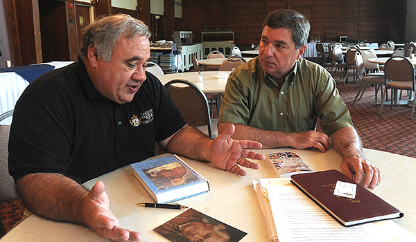 Christ the King Seminary professors Dennis Castillo and Paul Lubienecki look over material about Bishop John Timon in preparation for a program they are hosting at the seminary dining hall this September. (Dan Cappellazzo/Staff Photographer)