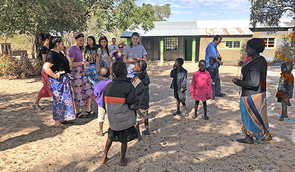 Students of Sacred Heart Academy play with the Zambian orphans they met in the summer of 2018 at preschool in Namushakende. (Courtesy of Sacred Heart Academy)