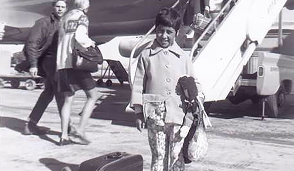 Lynn Stephens standing by an airplane in El Alto, Bolivia, ready to board to come to America. Stephens holds the Raggedy Ann doll that Sister Dorothy Feltz, SSJ, made for her. (Courtesy of Lynn Stephens)