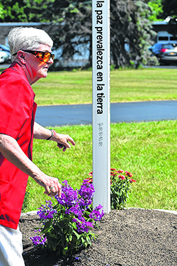 Sister Theresa Moore, SSJ, tends to the flowers that surround the Sisters of St. Joseph Peace Pole. (Courtesy of the Sisters of St. Joseph)
