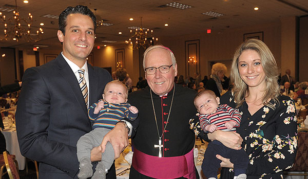 Bishop Richard J. Malone stands with Jeff and Maria Papia and their twin sons Joseph Baker Papia and Francis Micheal Papia at the Millennium Hotel during the 7th Annual St. Gianna Benefit Banquet. (Dan Cappellazzo/Staff Photographer)