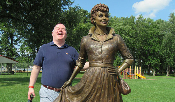 Parishioner Kevin Gavin shares a laugh with a statue of Lucille Ball while visiting the National Comedy Center in Jamestown. (Courtesy of Toni Drzewiecki)