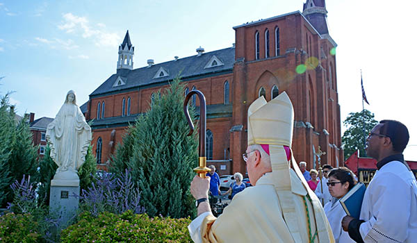 Bishop Ricahrd J. Malone blesses the new statue of Mary Aug. 14 after a Mass at St. John Kanty Church in Buffalo. The original statue was destroyed by a misguided youth who was granted forgiveness by the diocese. (Dan Cappellazzo/Staff Photographer)