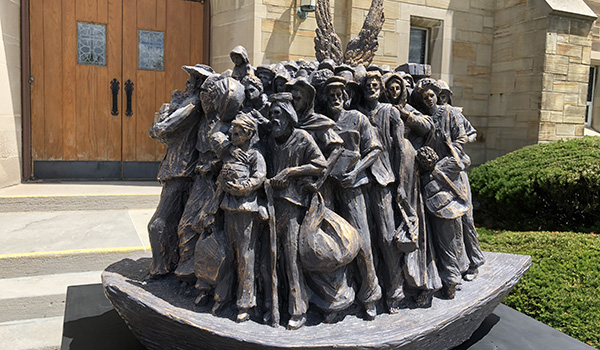 A sculpture depicting migrants was unveiled at St. Benedict Church in Eggerstville Wednesday afternoon. The parish hopes to raise funds for a future installation.