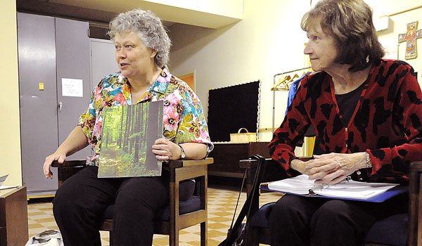 Kylie Mackenzie explains her feelings through pictures during the St. Ignatius retreat, as co-director Jan Sheridan listens. St. Ignatius retreat group meets in the rectory at St. Michael Parish in Buffalo. (Patrick McPartland/Staff Photographer)