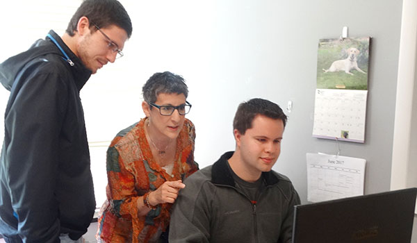 Looking over details of Storillo, an online program that facilitates student collaboration on group projects, are (from left) Thomas Wilkie, English teacher Joann Pera and Tim Adowski. Wilkie and Adowski founded the company.