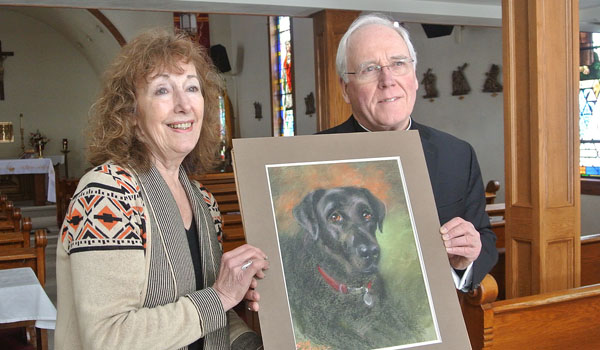 At the conclusion of United in Christ Our Hope, Bishop Richard J. Malone is presented with a pastel portrait of his dog, Timon, drawn by parishioner Sue Wolfe. (Courtesy of Dave Armstrong)