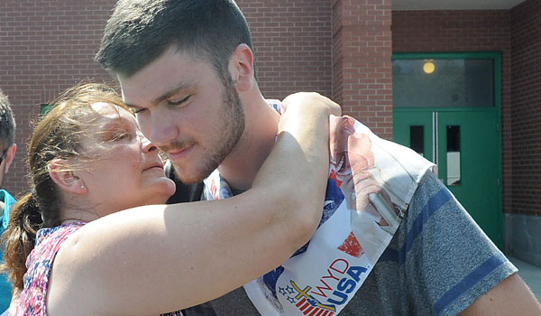 Joshua Miller (right) says goodbye to his mom, Donna, as World Youth Day pilgrims board buses to start the first leg of their journey to Poland. (Patrick McPartland/Staff Photographer)