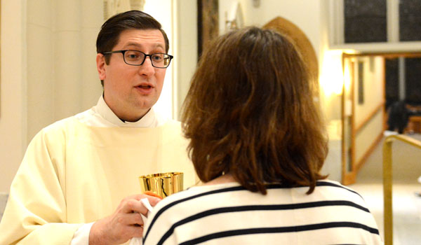 Deacon Cole Webster offers communion at the annual Chrism Mass at St. Joseph Cathedral in April. (Patrick McPartland/Managing Editor)