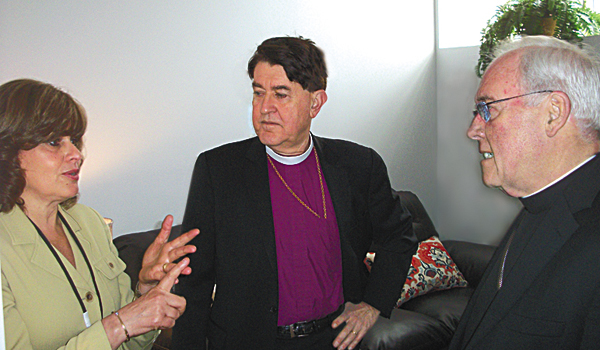 Mary Travers Murphy (from left) of the Family Justice Center speaks to Bishop R. William Franklin of the Episcopal Diocese and Bishop Richard J. Malone of the Catholic Diocese. (Photo by Kimberlee Sabshin)