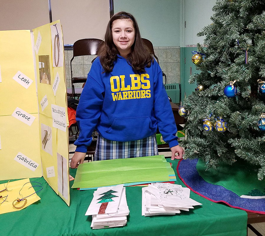 Taylor Johnson sells Our Lady of the Blessed Sacrament ornaments that the 7th-grade made for the Christmas Bazaar. (Photo Courtesy of Our Lady of the Blessed Sacrament)