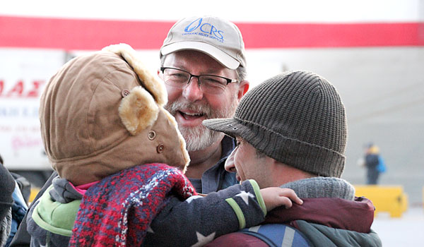 Deacon Don Weigel smiles with a refugee family as he ministers to Syrian refugees in Greece and Serbia. (Courtesy of Deacon Don Weigel)