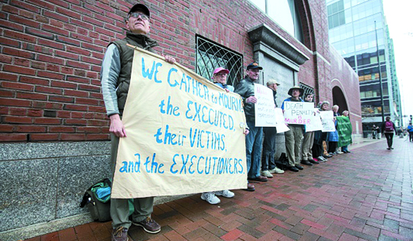 Death-penalty protesters stand outside of the United States federal courthouse during the first day of the sentencing phase of the Boston Marathon bombing trial of Dzhokhar Tsarnaev. (Scott Eisen/Getty Images)