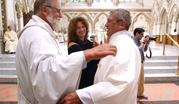 Deacon Ted Pijacki (from left) and Karen Birmingham help newly ordained deacon Edward Birmingham with his stole and dalmatic during the Ordination of Deacons at St. Joseph Cathedral. (Patrick McPartland/Managing Editor)