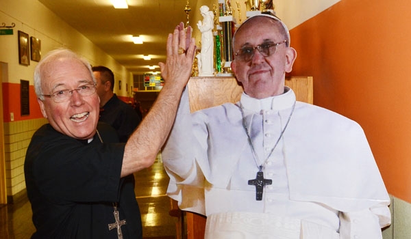 Bishop Richard J. Malone high-fives a cardboard standee of Pope Francis at the Catholic Academy of West Buffalo during the first day of school. (Patrick McPartland/Staff Photographer)