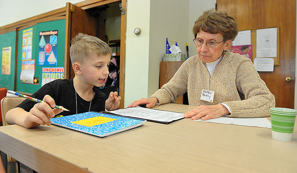 Sister Betty Neumeister, OSF, director of the Francis Center, spends time with a child at the center's after school program in Niagara Falls. (Patrick McPartland/Staff Photographer)