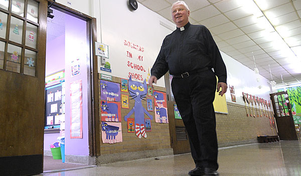 Father Richard Jedrzejezski walks the same hallways he and Bishop Edward M. Grosz walked as classmates at Assumption School. Fr. Jedrzejezski is currently pastor at Assumption Church and the school is now known as Our Lady of Black Rock. (Patrick McPartland/Staff Photographer)