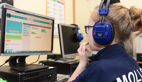 Mary Molloy, fourth-grader at Queen of Heaven School, focuses on her task at hand as she takes part in the Hour of Code this week. The Hour of Code introduces students across the globe to the world of computer coding. (Patrick McPartland/Staff Photographer)