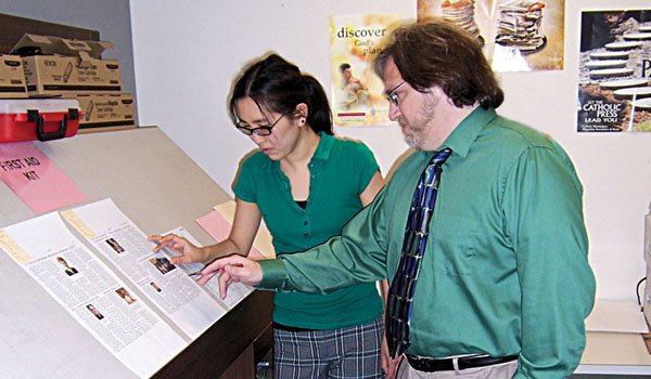 Staff members of the Western New York Catholic, Kimberlee Sabshin and Patrick Buechi, edit proofs of the diocesan paper in one phase of getting ready for print.