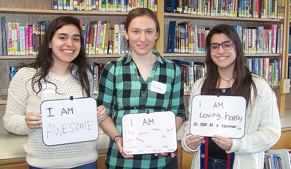 Veronika Tibold, Sarah Zielinski and Maria Tibold pose for a photomosaic with their `I Am` whiteboards. This was just one activity held during `Mercy Awakens,` a preparation retreat for World Youth Day pilgrims held April 3 at the Church of the Annunciation in Elma. (Patrick J. Buechi/Staff)