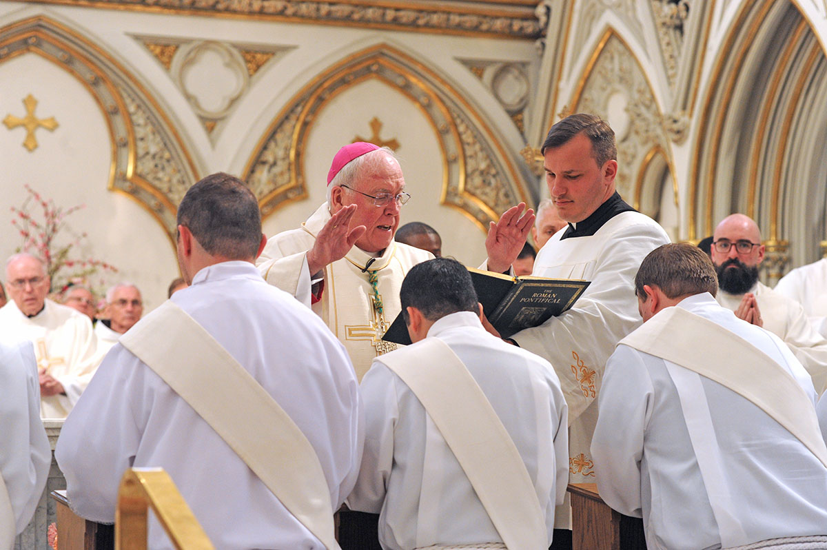 Dan Cappellazzo/Staff Photographer - Bishop Richard J. Malone prays over the priestly candidates as eight men are ordained to the priesthood during ceremonies at St. Joseph Cathedral.