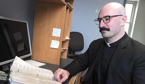Deacon Peter Santandreu does clerical work at the Christ the King Seminary administration building. He will be ordained at St. Joseph Cathedral in June. (Dan Cappellazzo/Staff Photographer)