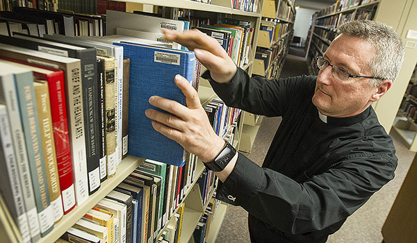 Deacon Gerard Skrzynski works in the library at Christ the King Seminary. (Dan Cappellazo/Staff Photographer)