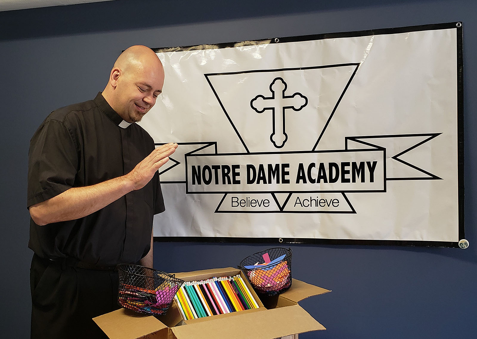 Father Bryan Zielenieski pastor of Our Lady of Charity blesses pencils for the school students. The pencils are inscribed with the words, `Someone is praying for you.`

Courtesy of Notre Dame Academy
